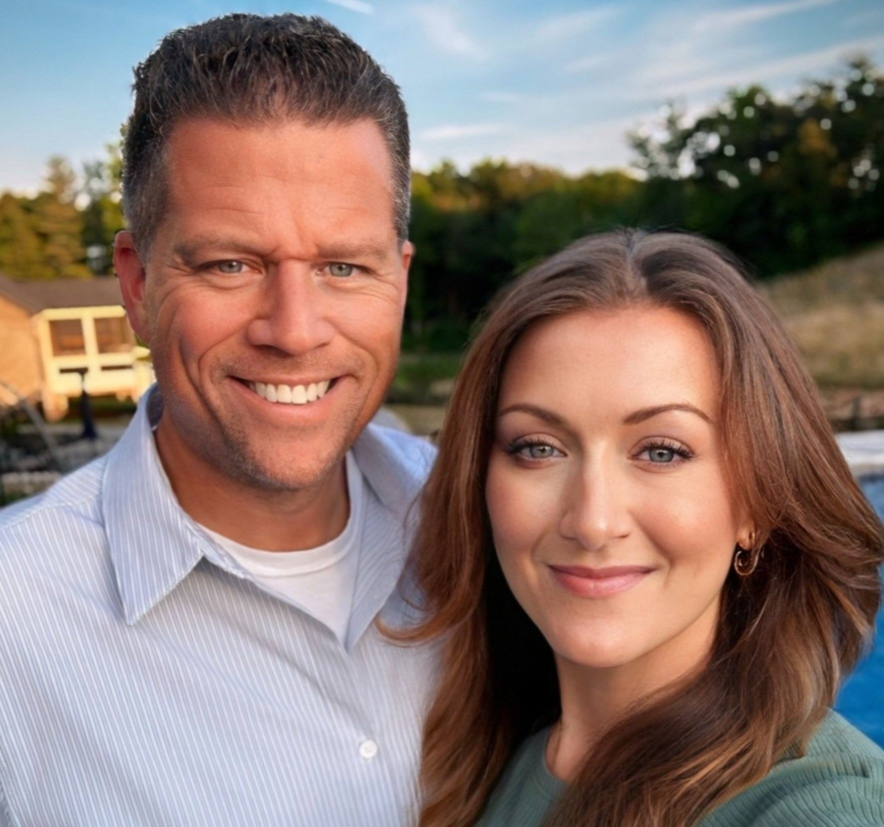 Jess and Ryan smiling outdoors with trees in the background.