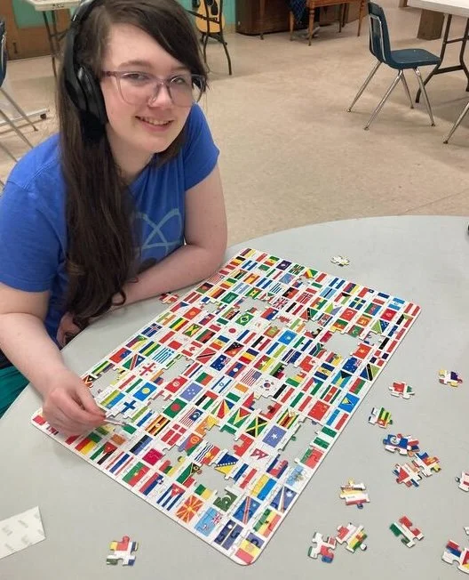 Person assembling a flag jigsaw puzzle at a table