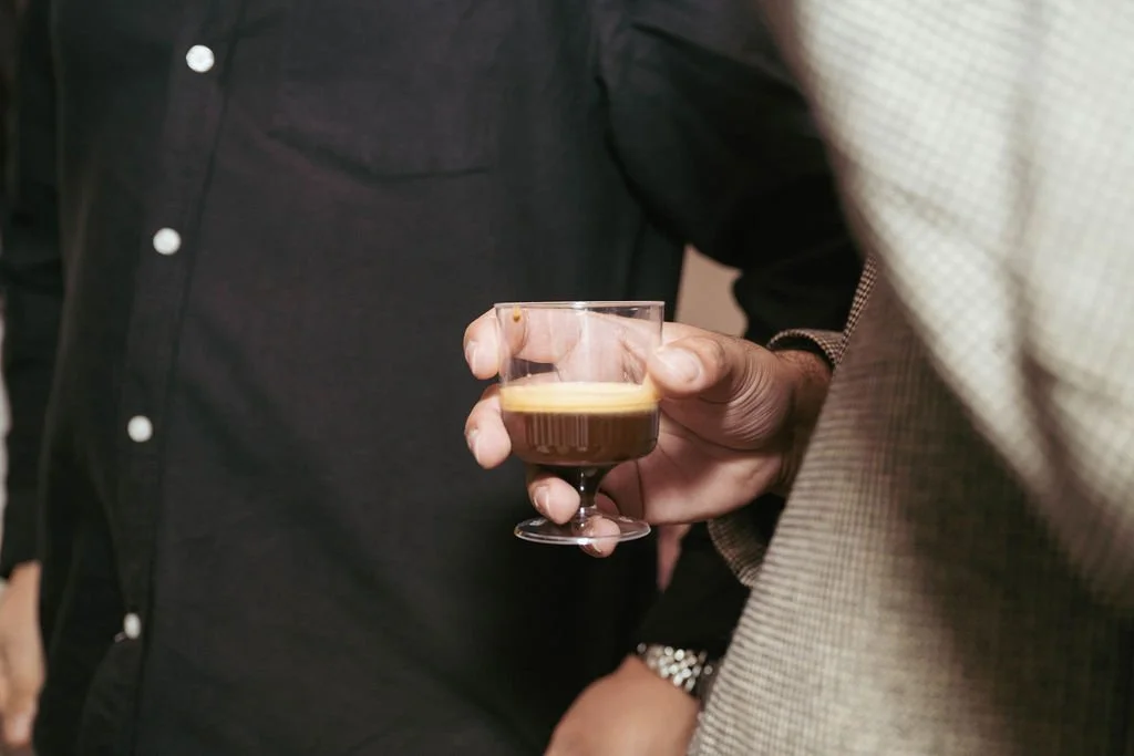 Person holding a glass of coffee.