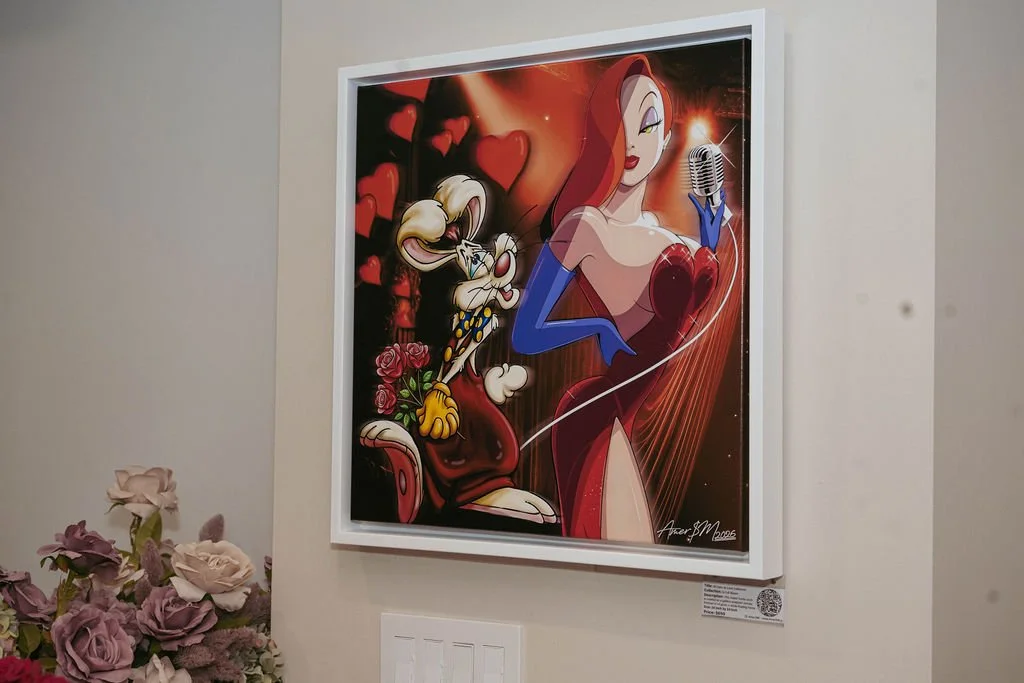 A framed digital illustration of Disney characters, Jessica Rabbit and Roger Rabbit, with Jessica holding a microphone, surrounded by hearts and roses, hanging on a wall.