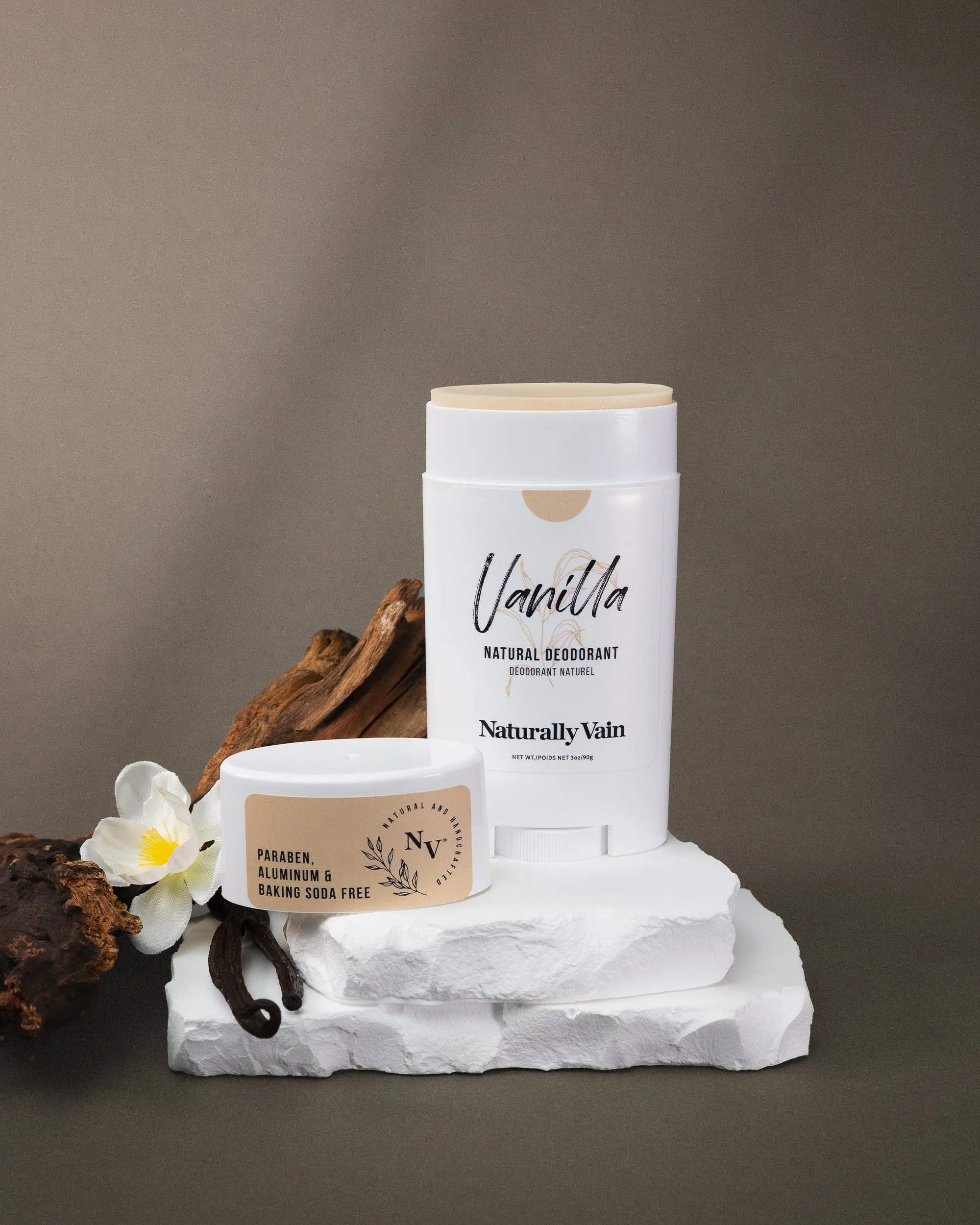 Natural deodorant and paraben-free product with vanilla, flowers, and wood on a textured white base.