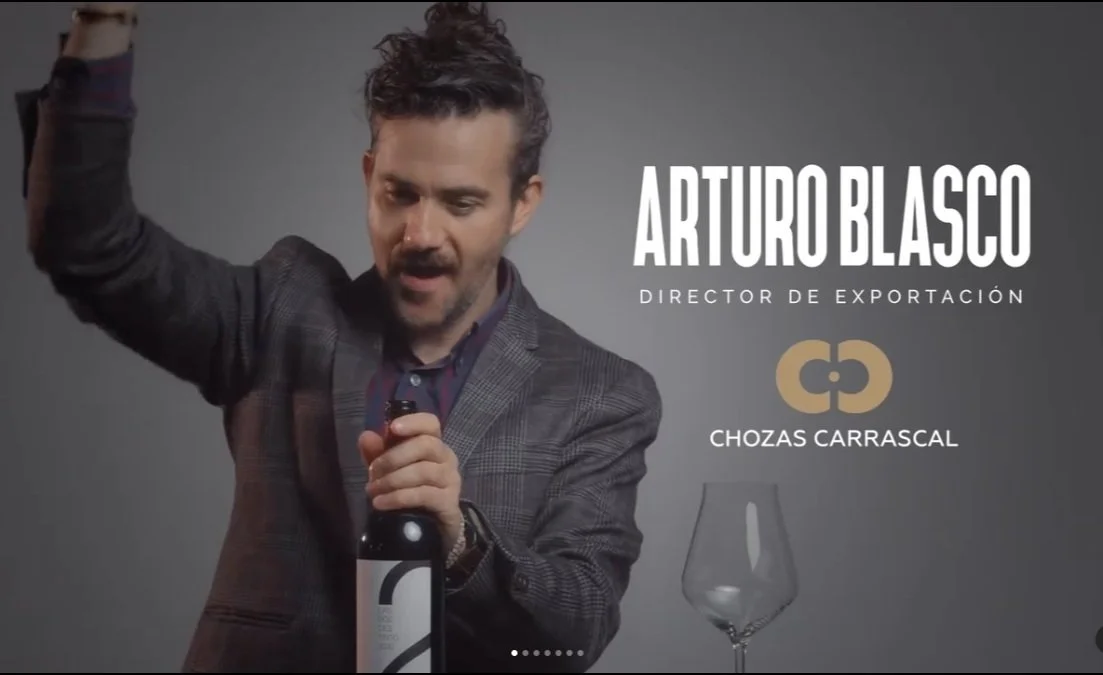 Man holding wine bottle with glass and text indicating position as Director of Exportation at Chozas Carrascal.