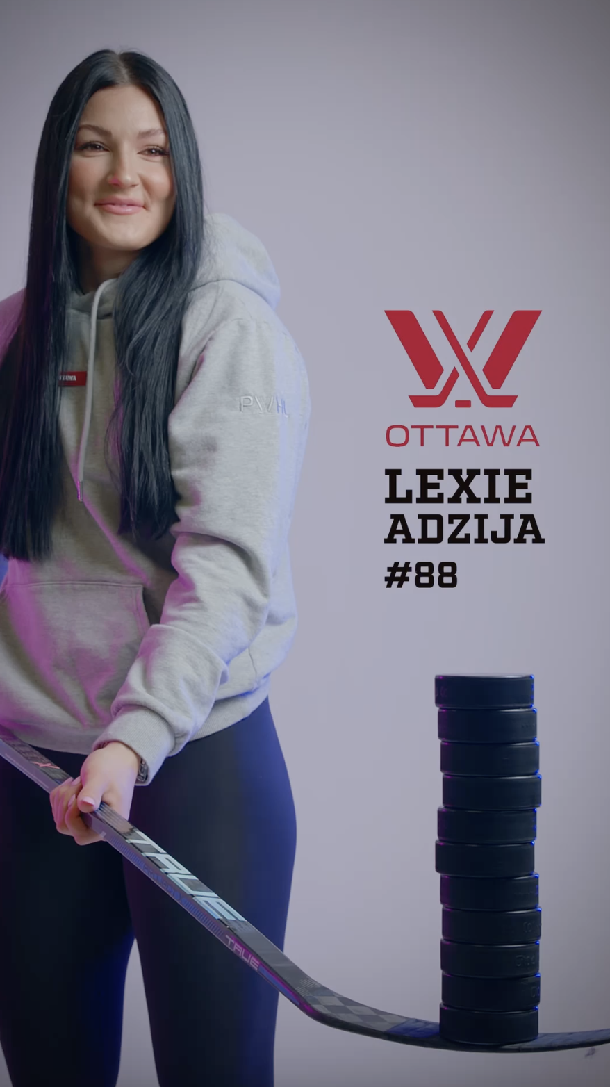 Person in a gray hoodie holding a hockey stick with a stack of pucks on it; text reads "Ottawa, Lexie Adzija, #88" with a logo.