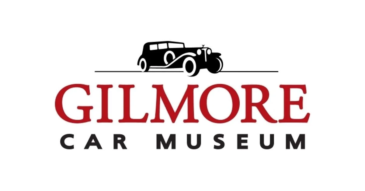 Logo for Gilmore Car Museum featuring a black vintage car and red and black text.