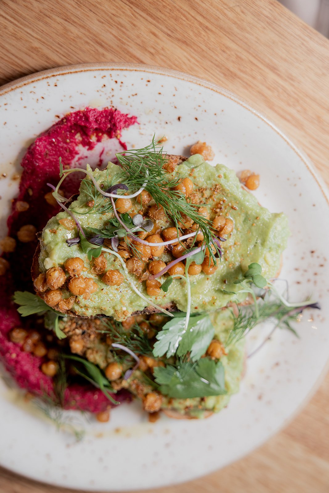 Smashed Avocado on sourdough toast with beetroot hummus, crispy chickpeas and microgreens. Vegan and Vegetarian friendly. Gluten Free option available.