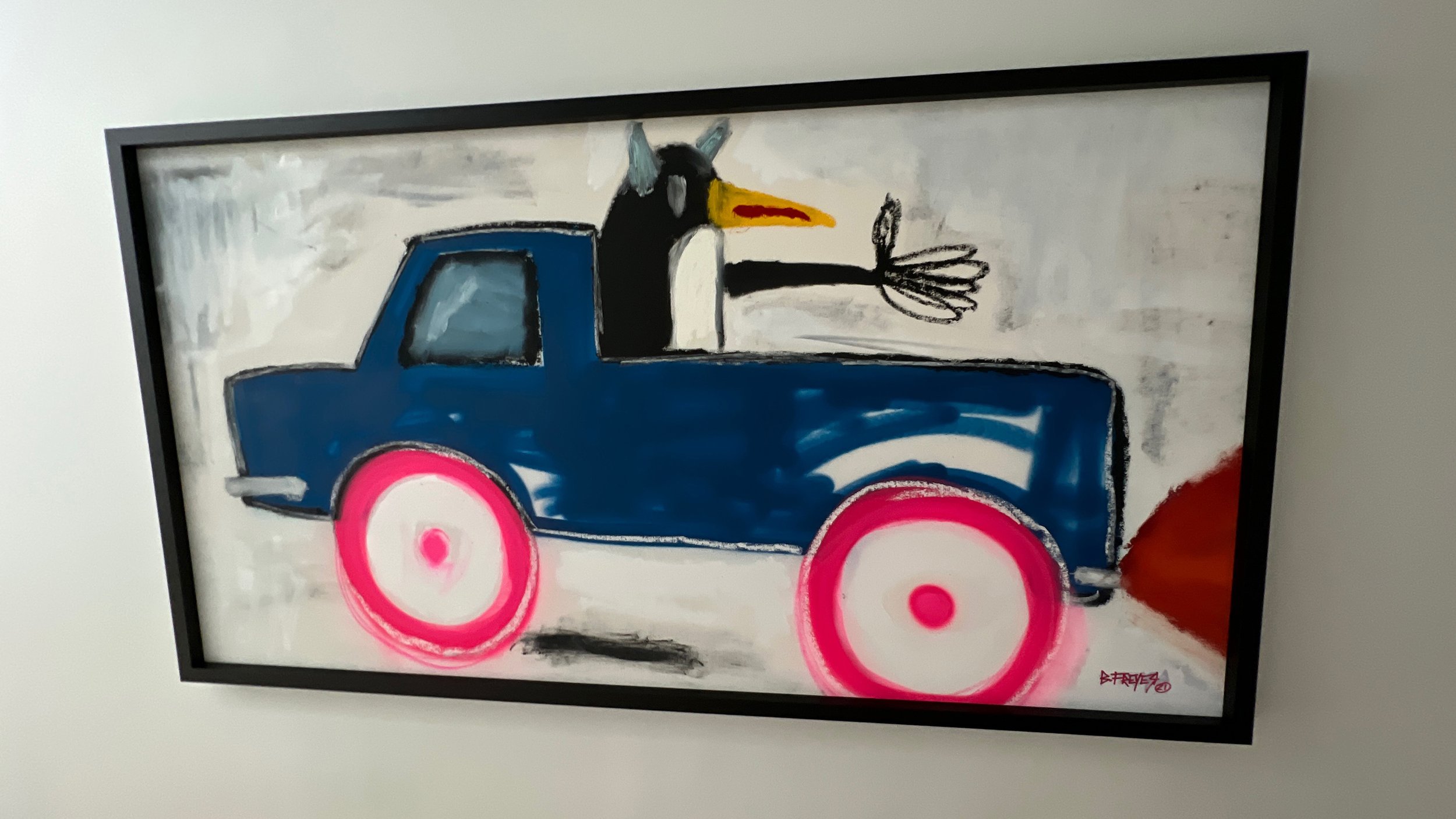 Framed painting of a cartoon bird driving a blue car with pink wheels.