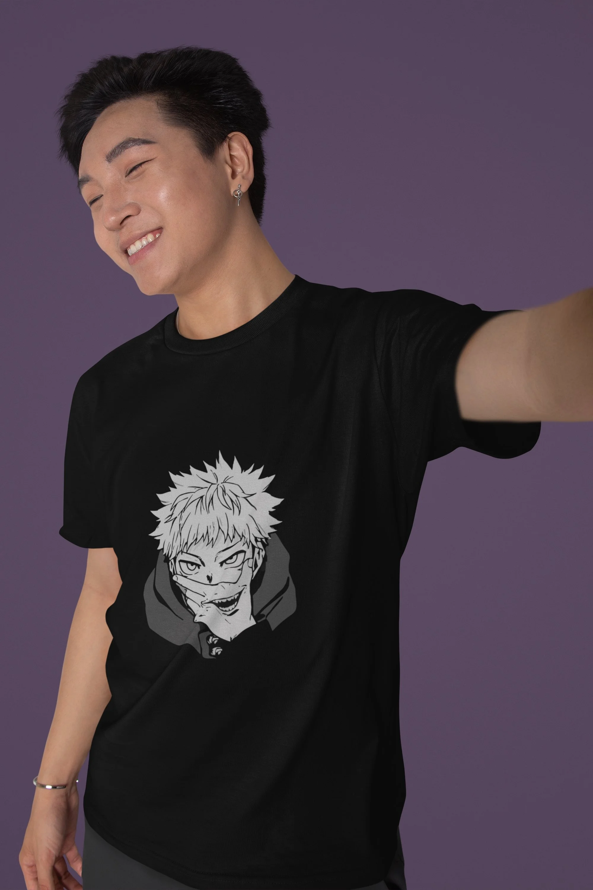 Young man smiling and taking a selfie, wearing a black T-shirt with anime-style graphic on it, against a purple background.