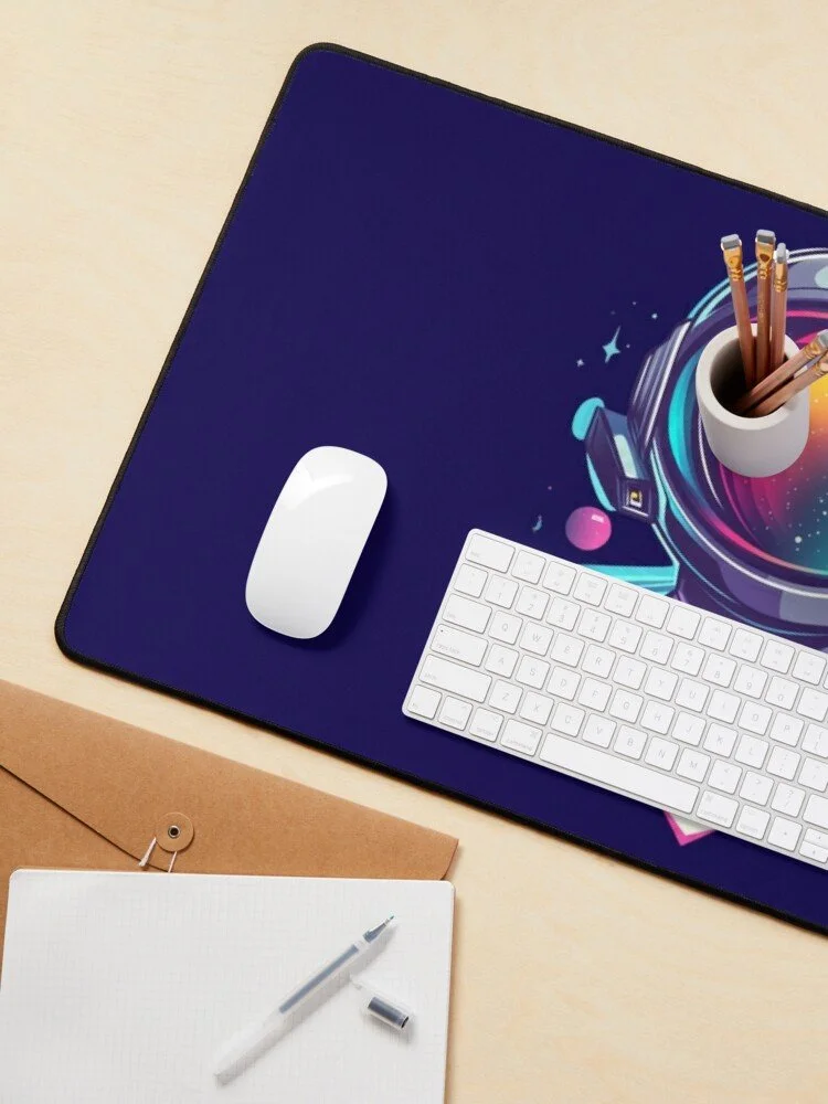 Desk with a colorful mouse pad featuring space-themed graphics, a white wireless mouse, a white wireless keyboard, a white pen with its cap off, and a white cup holding several pencils, all on a light wooden surface.