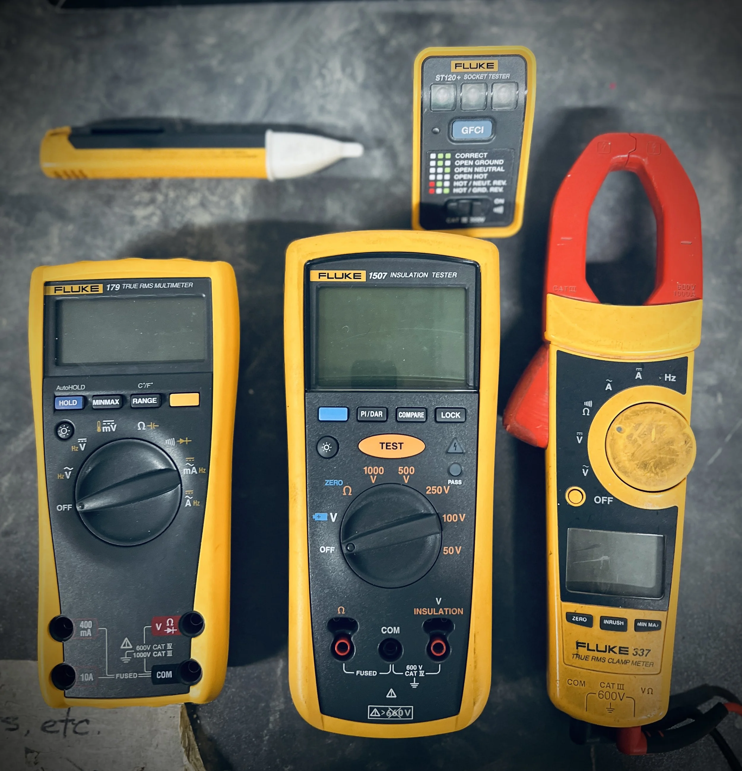 A digital multimeter showing a voltage of 123.8 volts, testing an electrical meter box with wires and components inside.