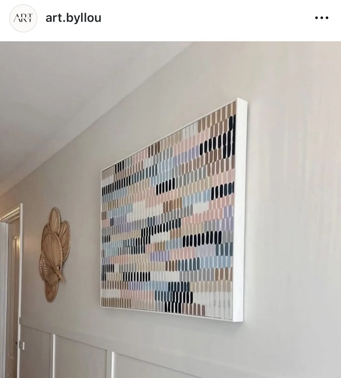 Abstract wall art with multicolored vertical rectangular shapes on a white wall