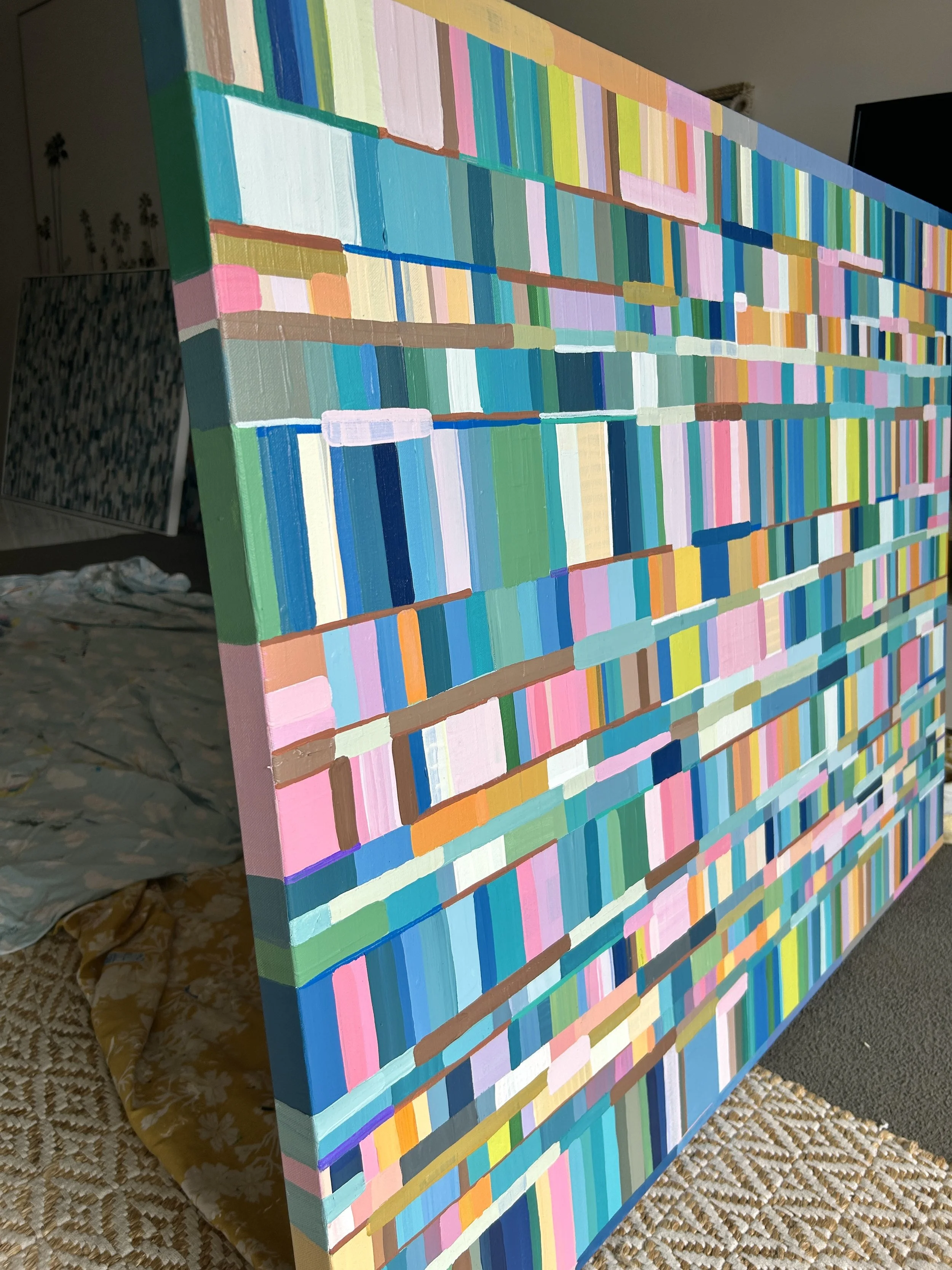 Close-up of a colorful abstract painting featuring horizontal rows of multicolored rectangles and lines, with visible textured brushstrokes.