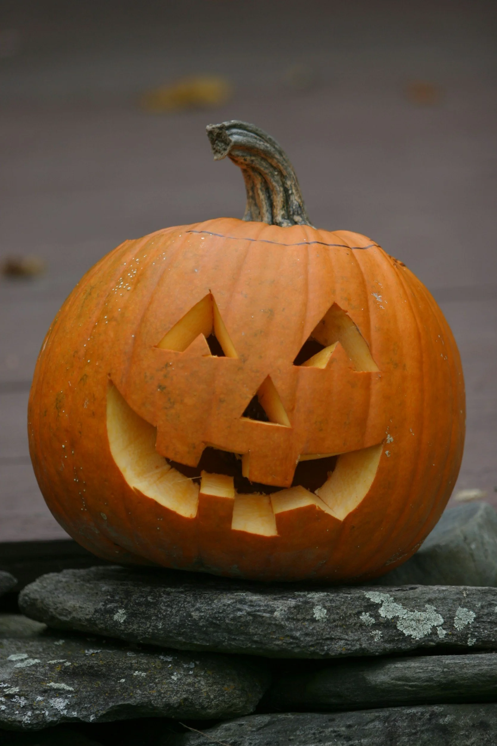 Pumpkin carved with two triangle eyes, triangle nose, and a toothy grin.