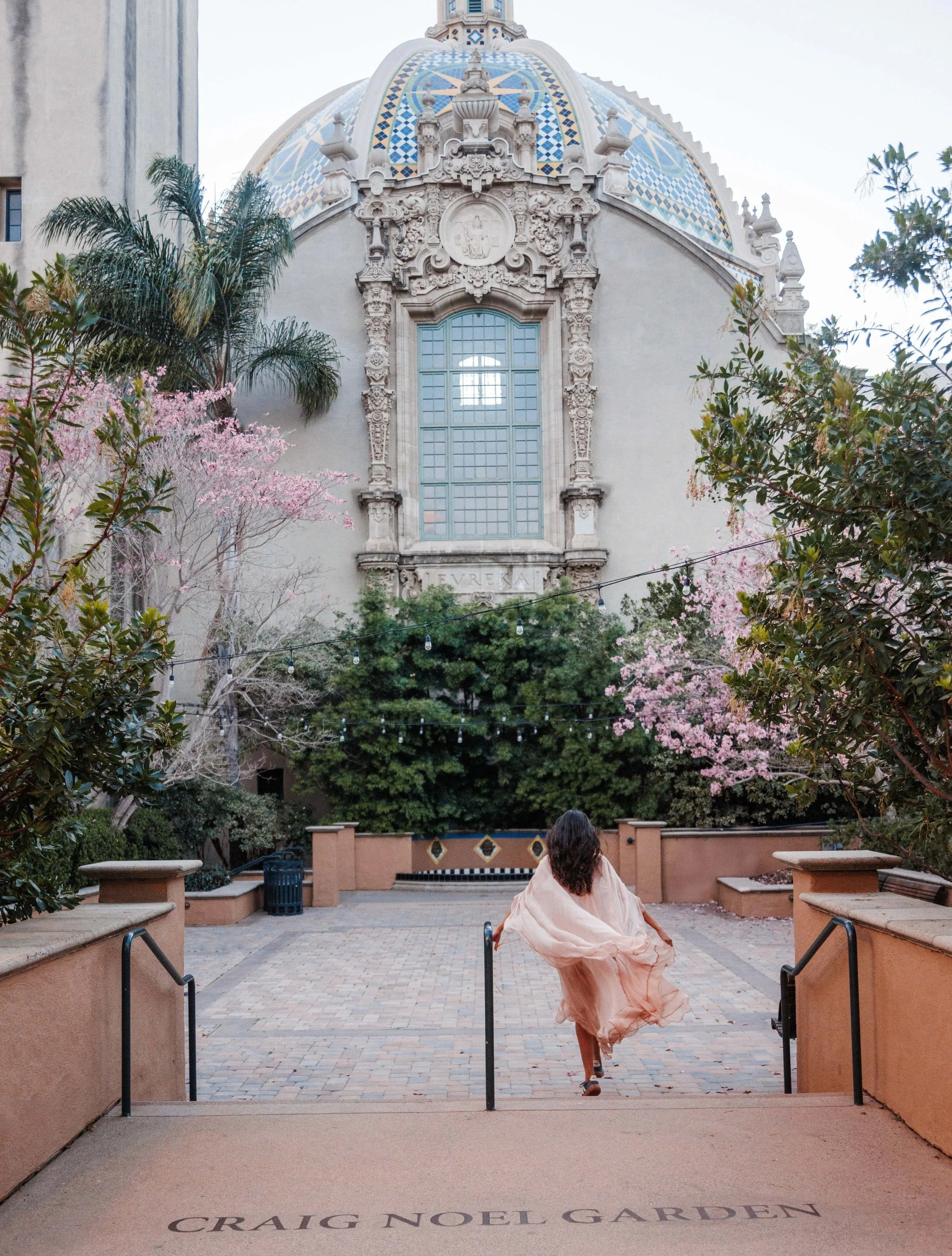 The Noun Magazine Balboa Park Botanical Building San Diego with person walking in garden courtyard
