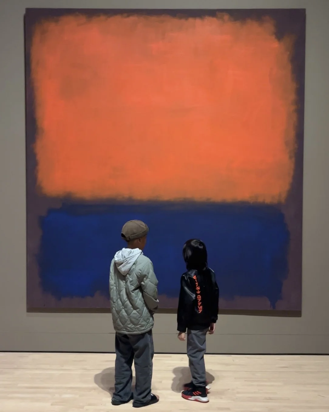 KēMa Mo, contributors to The Noun's Kids Menu, stand before Mark Rothko's monumental orange-and-blue painting No. 14, 1960 at RM x SFMOMA: Between You and Me in San Francisco.