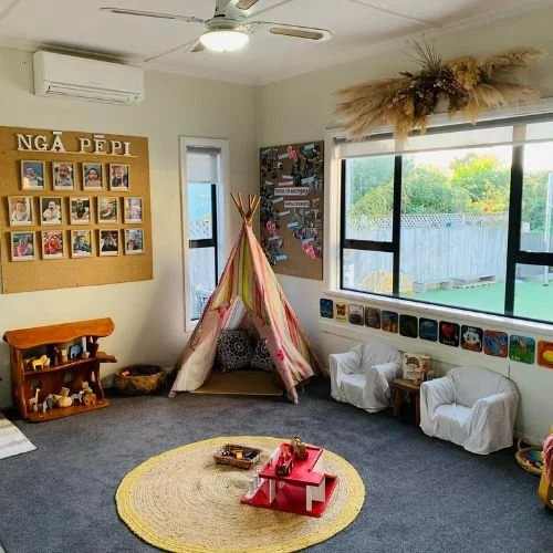 Ngā Pēpi indoor learning space  A warm and inviting infant room at Happy Days Taradale, featuring a tipi, natural resources, and personal photo wall for each pēpi.
