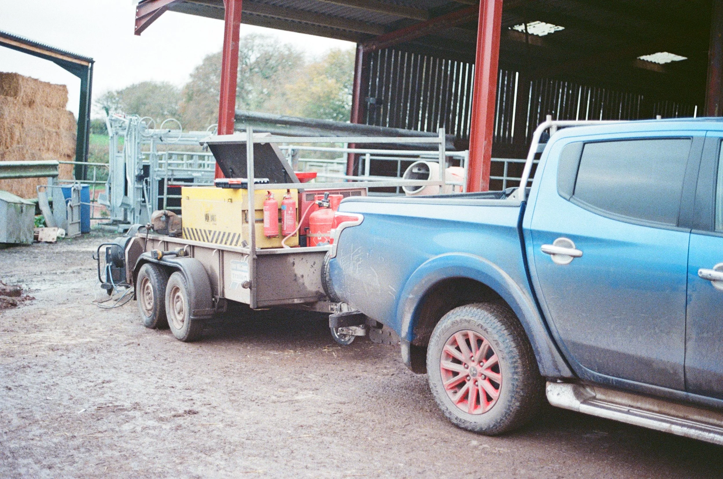 Blue pickup truck with attached mobile welding skid trailer