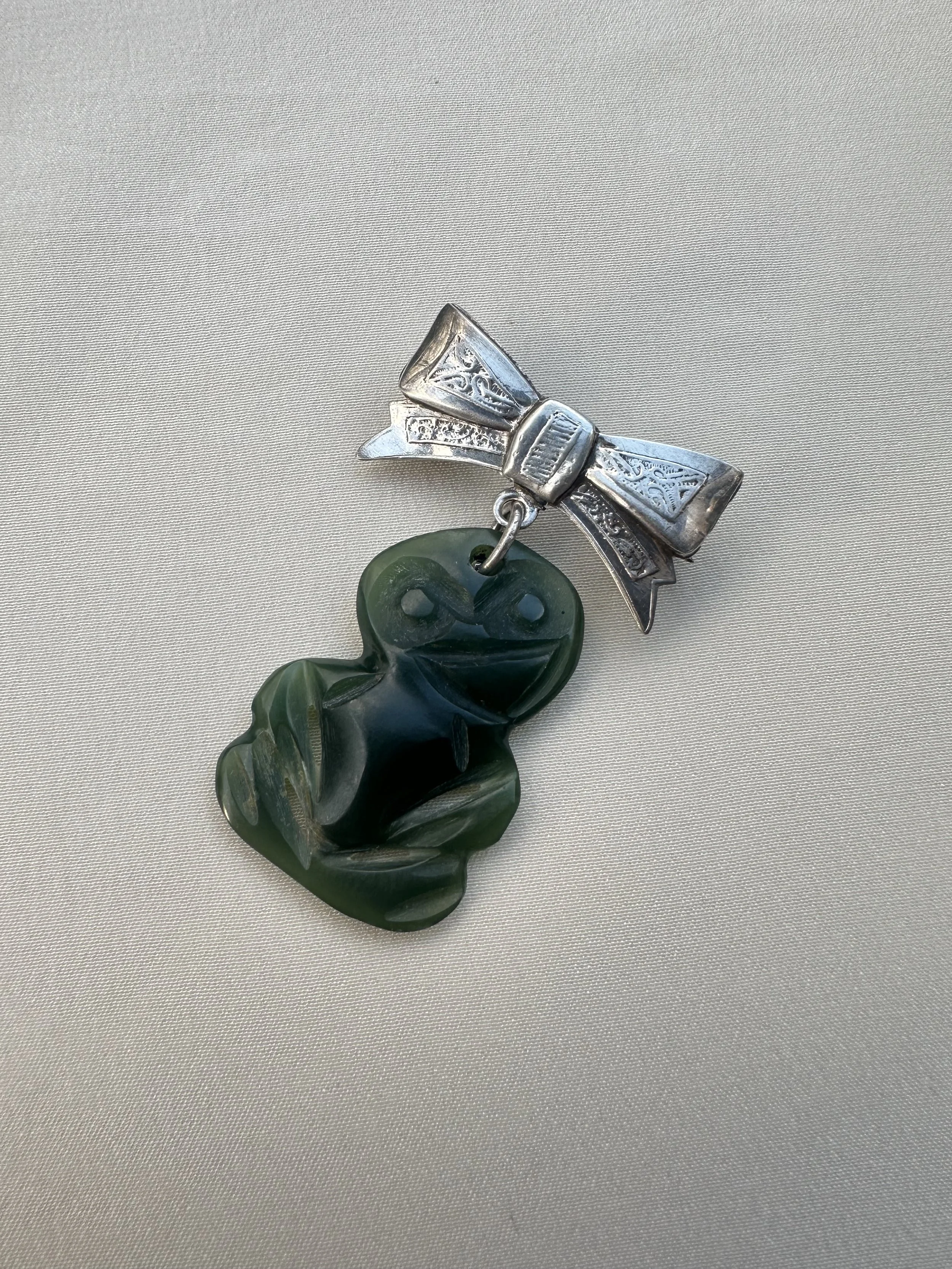 Rare early 1900s Pounamu hei tiki on 925 bow brooch