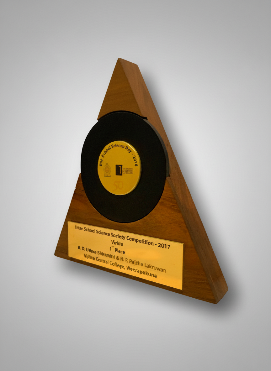 A wooden triangular trophy with a vinyl record embedded in it, with a gold plaque indicating it is for a science competition award.