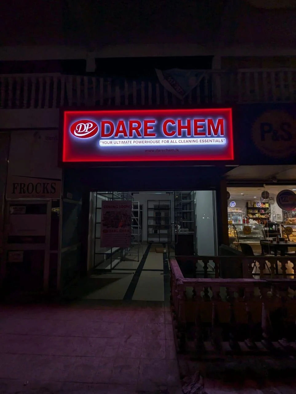 Neon sign for Dare Chem with the tagline "Your Ultimate Powerhouse for All Cleaning Essentials" illuminated at night