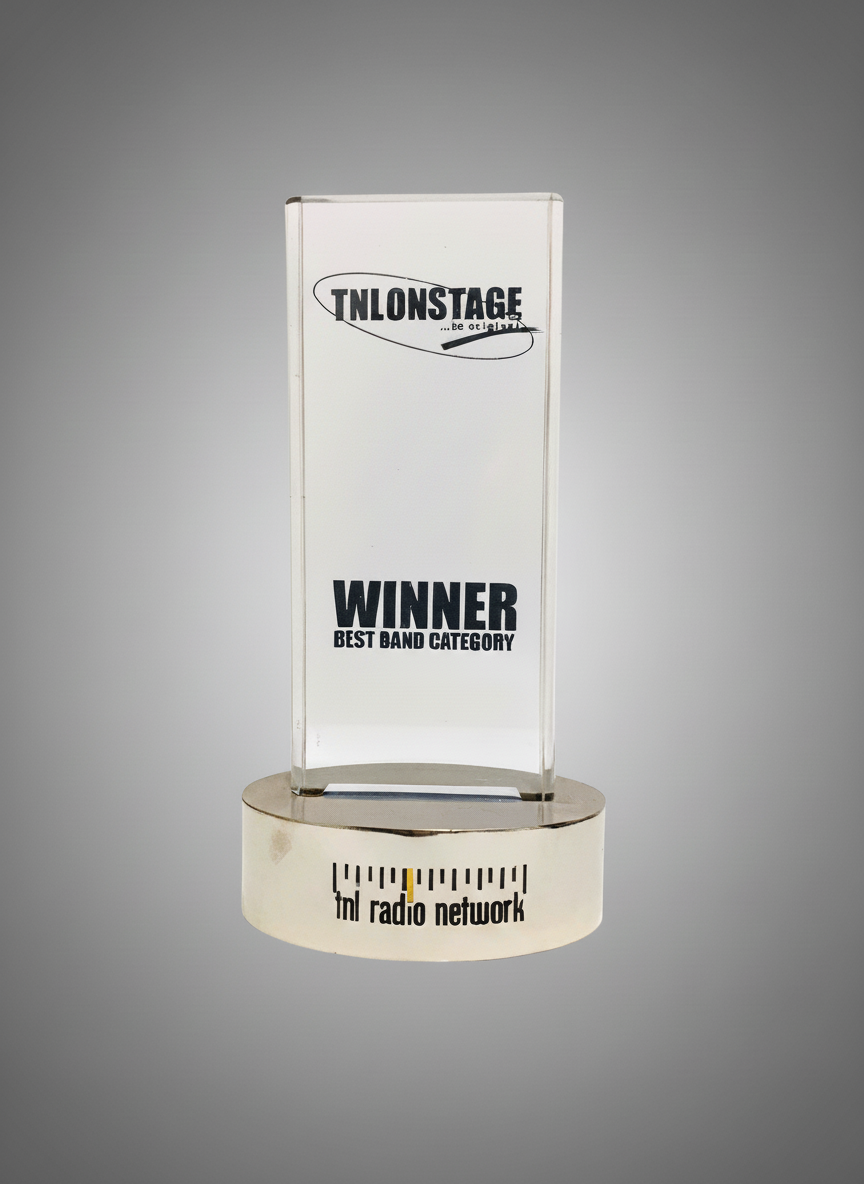 A trophy with a transparent rectangular plaque on a round base, displaying the text 'ON STAGE...be ou' at the top, 'WINNER' in large bold font, and 'BEST BAND CATEGORY' below it, with 'fnl radio network' written on the base.