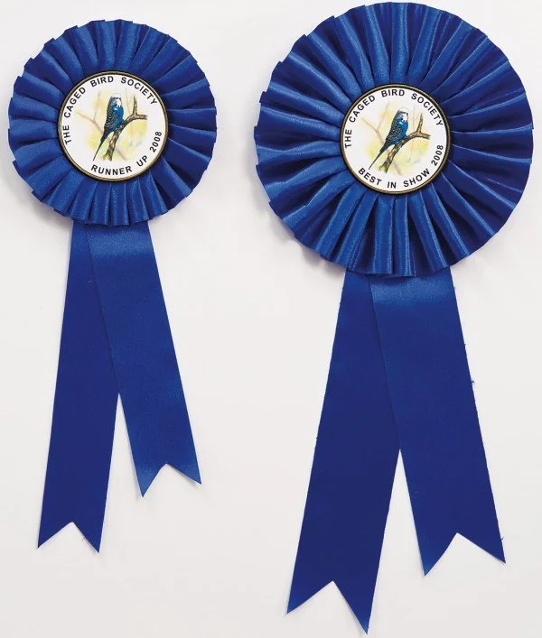 Two blue award ribbons with the logo of the Caged Bird Society, featuring a bird, and text about a show competition from 2008.