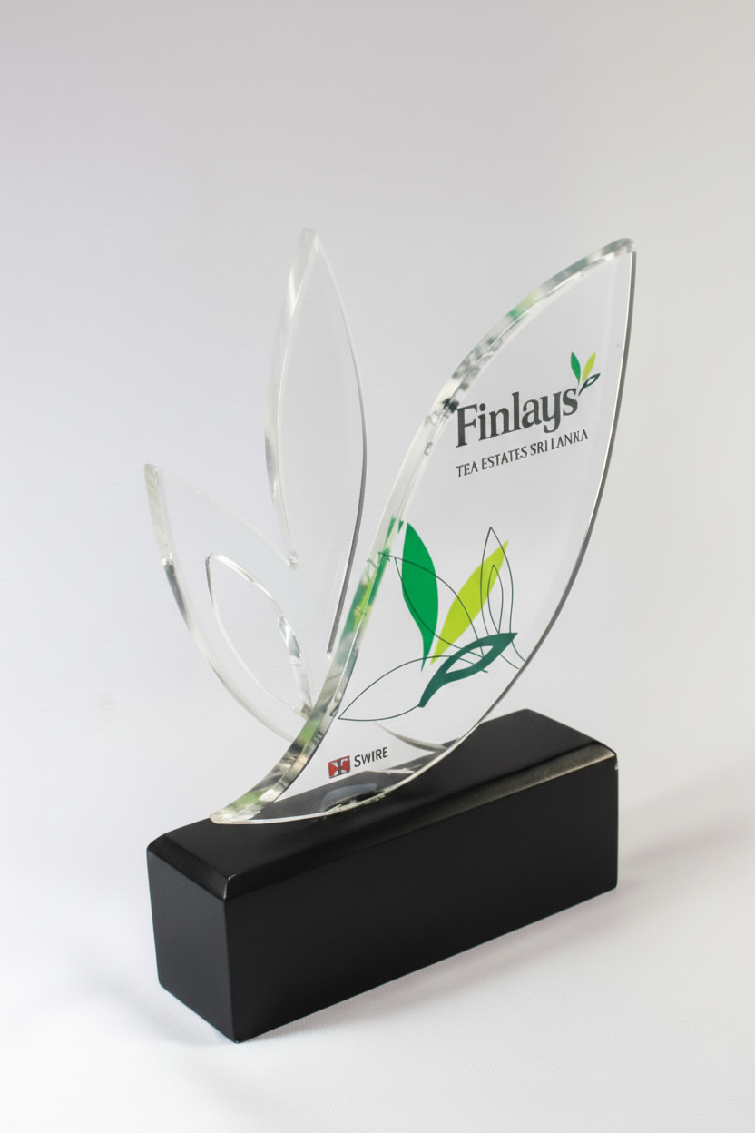 Crystal award with green leaf design and black base, featuring the text 'Finlays, Tea Estates Sri Lanka' and a logo.