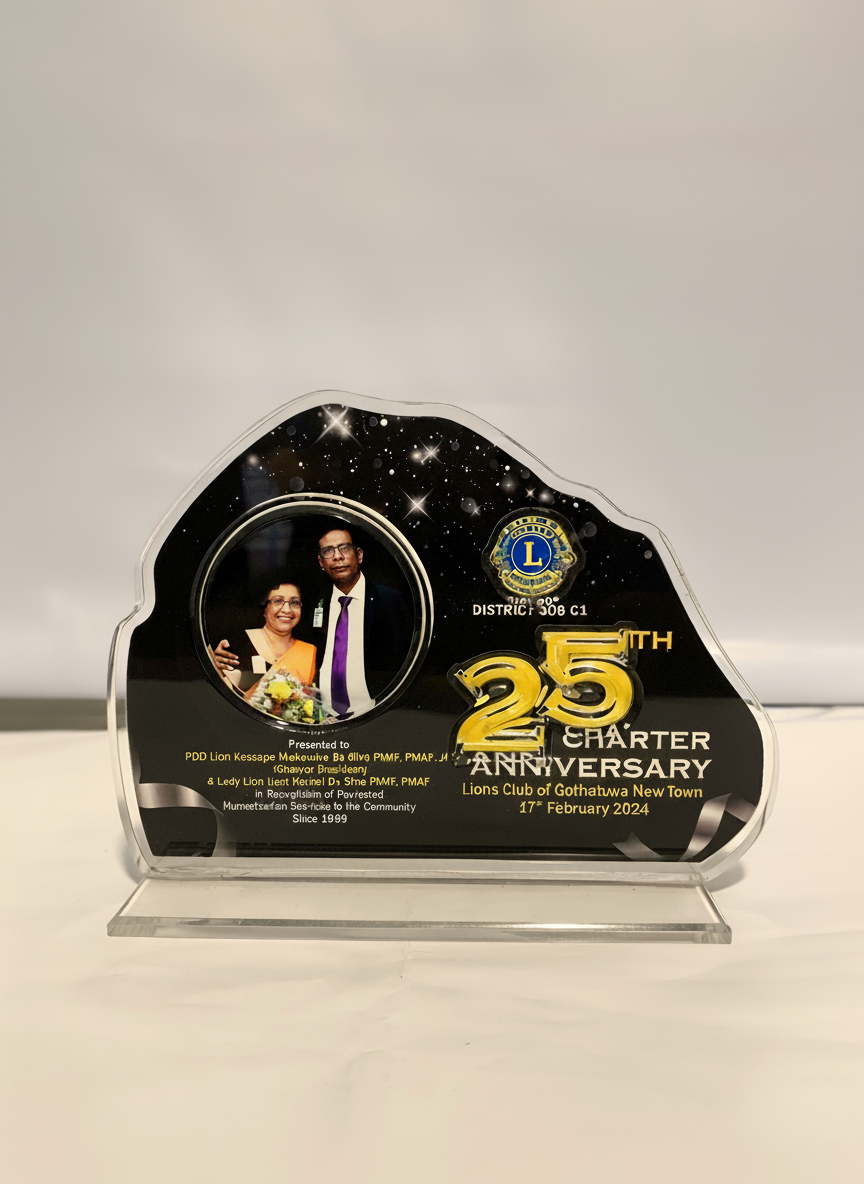 A commemorative plaque with a photo of a man and woman, Lions Club logo, and gold lettering celebrating the 25th anniversary of Lions Club of Gothawwa New Town on February 17, 2024.