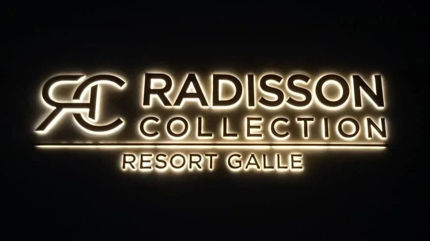 Illuminated sign displaying the Radisson Collection logo and text for Resort Galle.