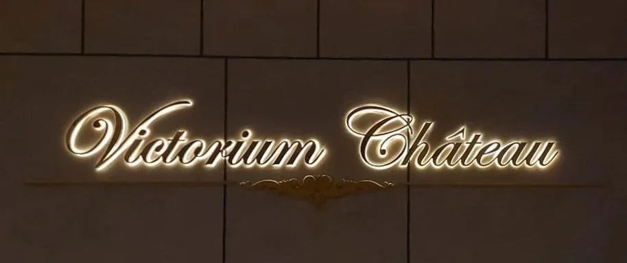 Neon sign reading 'Victorium Château' mounted on a tiled wall.