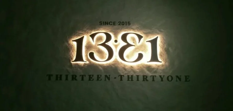 A logo with the number 1381 and the words 'Thirteen-ThirtyOne,' illuminated against a dark background, with 'Since 2015' above.