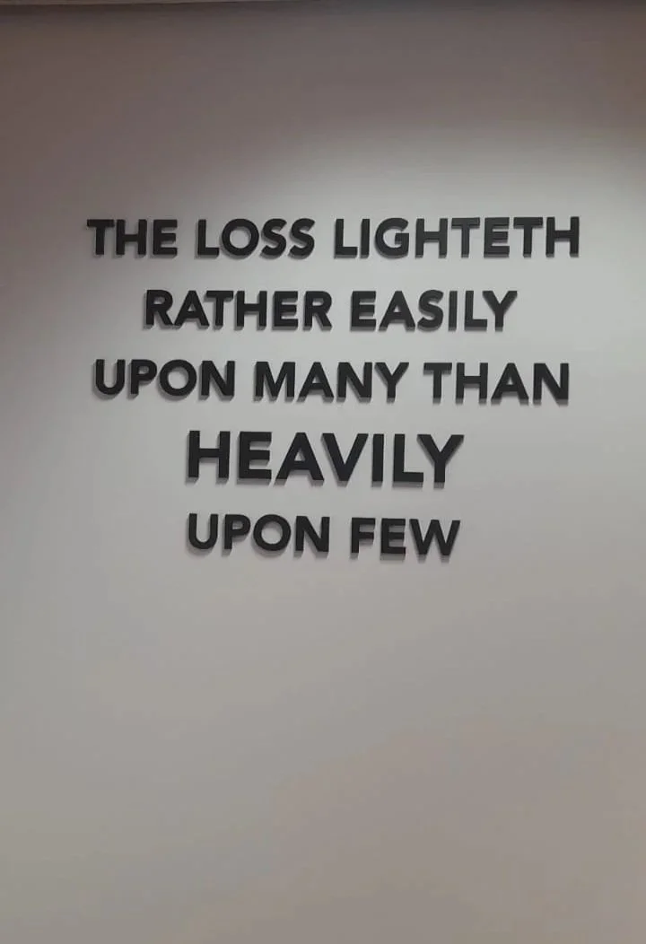 Quote on a white wall that reads, "The loss lighteth rather easily upon many than heavily upon few."