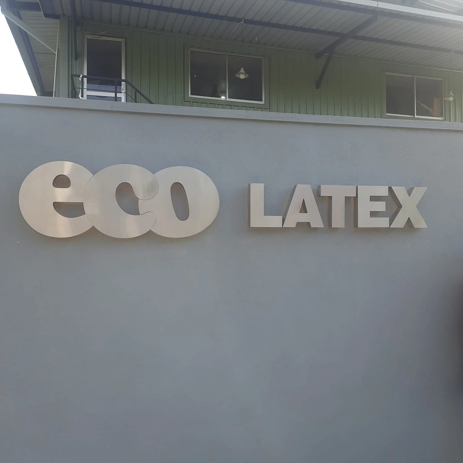 Sign on a wall that reads 'ECO LATEX' with the letters in white and a modern font.