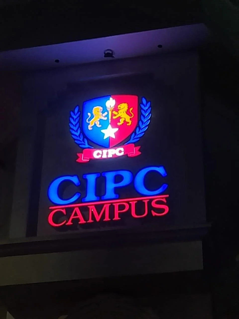Illuminated sign for CIPC Campus featuring a crest with lions and a star.