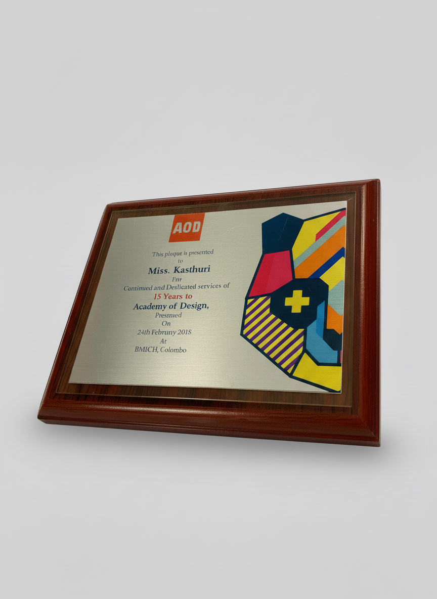 Wooden framed plaque with colorful abstract design and text honoring Miss. Kasthuri for 15 years of service to an Academy of Design, presented on February 24, 2015, at BMICH Colombo.