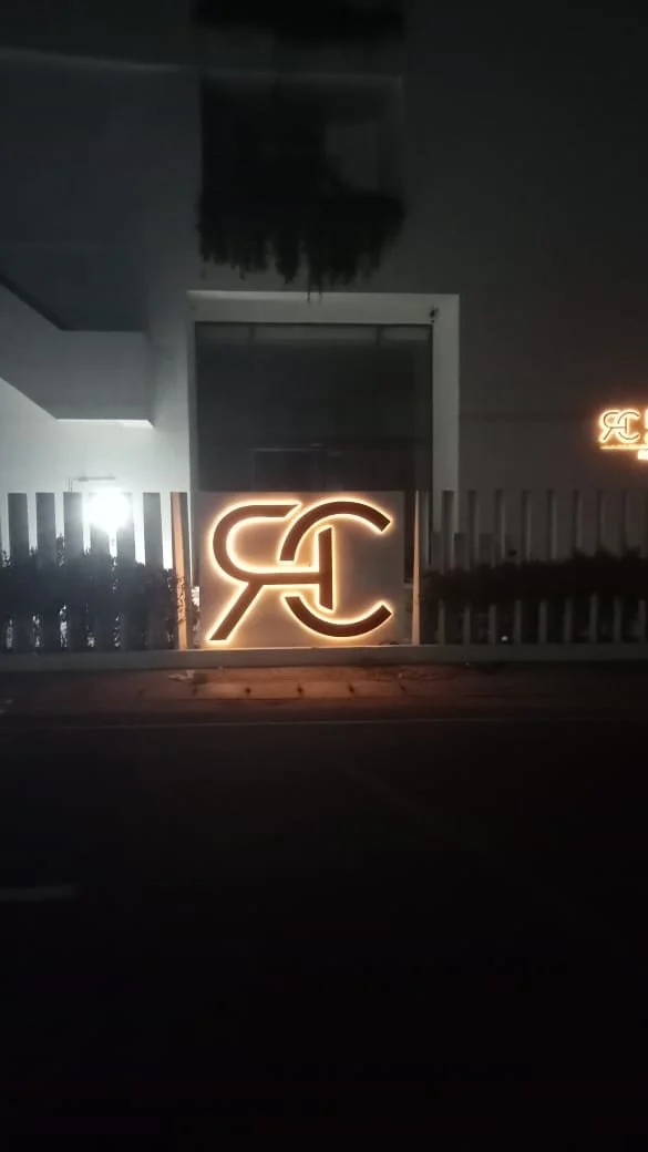 Illuminated logo with intertwined letters 'S' and 'C' on a building at night.