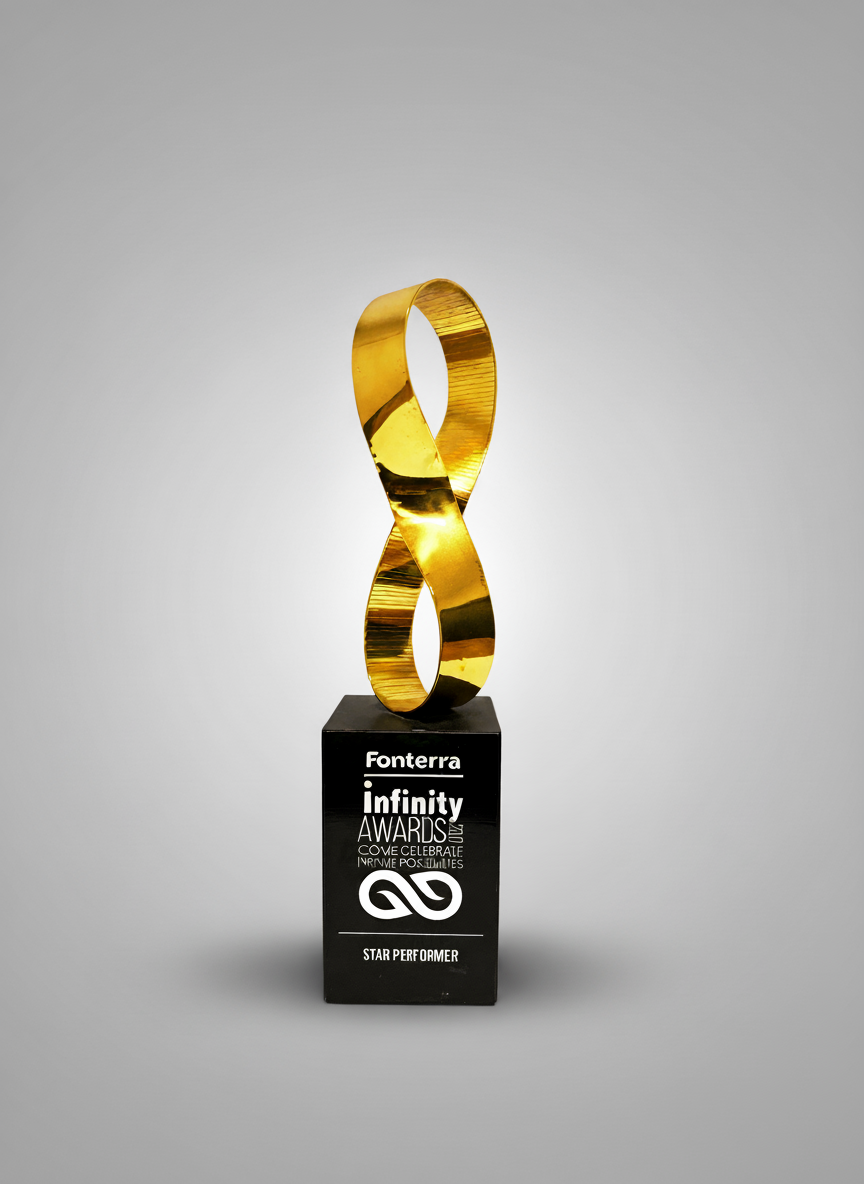 A black trophy with a gold infinity-shaped sculpture on top, engraved with 'Fonterra infinity AWARDS' and 'STAR PERFORMER', against a plain gray background.