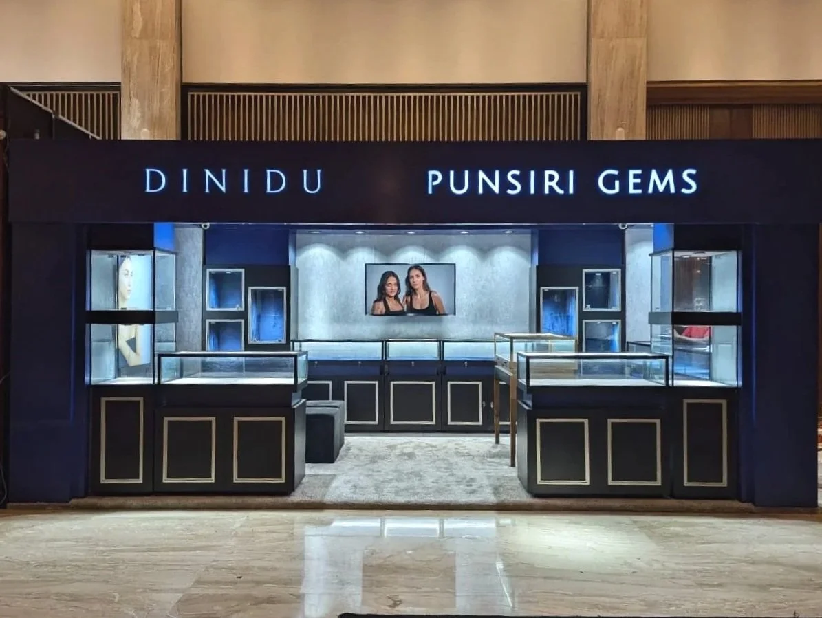 Jewelry display booth with the signs 'Dinidu' and 'Punsiri Gems' at a store or exhibition