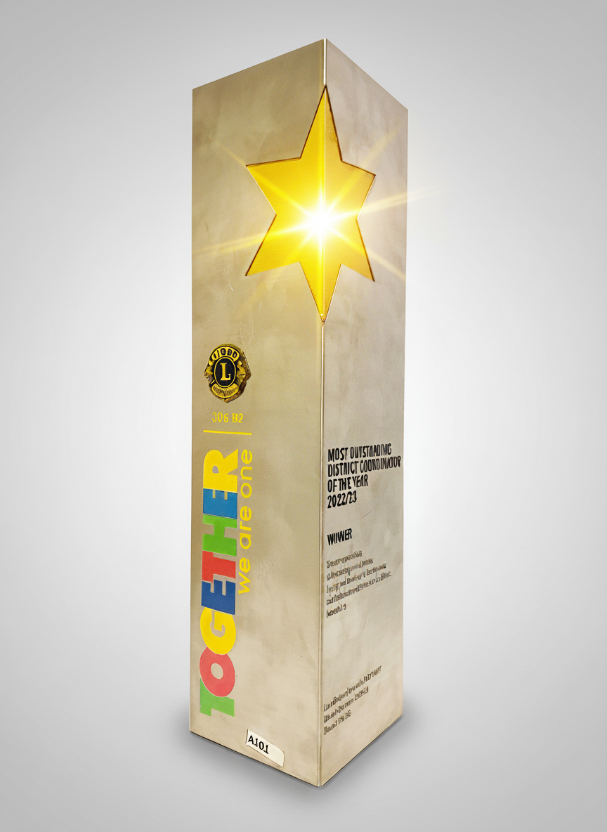 A tall award trophy with a star-shaped cutout emitting light, decorated with colorful letters spelling 'TOGETHER' and the words 'we one' underneath. The trophy has a Lions Club emblem and text acknowledging it as the Most Outstanding District Coordin