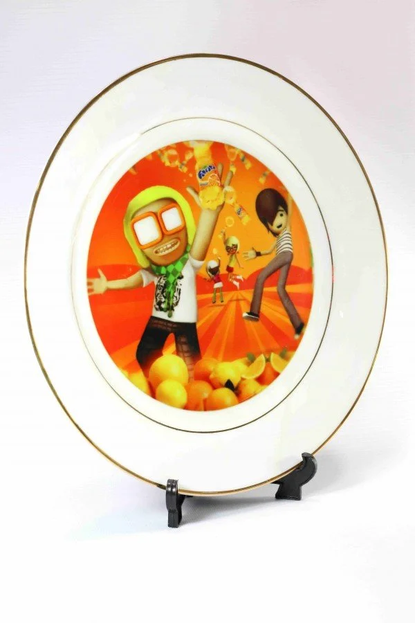 Decorative plate with animated characters and fruit, featuring a background with bright orange and yellow colors.