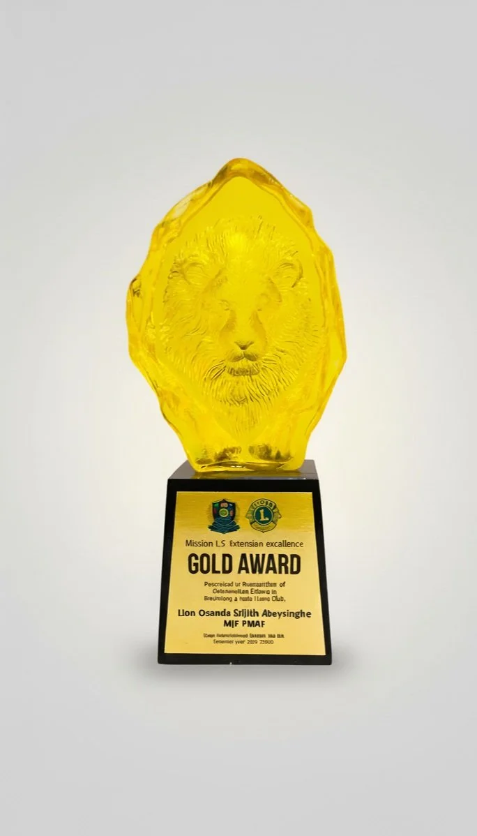 Yellow glass award shaped like a lion's head on a black and gold base with a plaque.