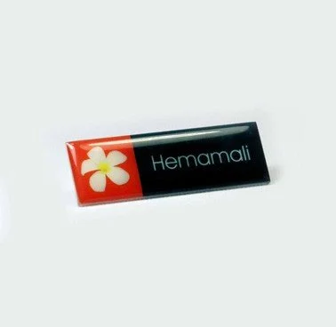 A small rectangular item with a red flower graphic and the word 'Hemamali' on a black background.