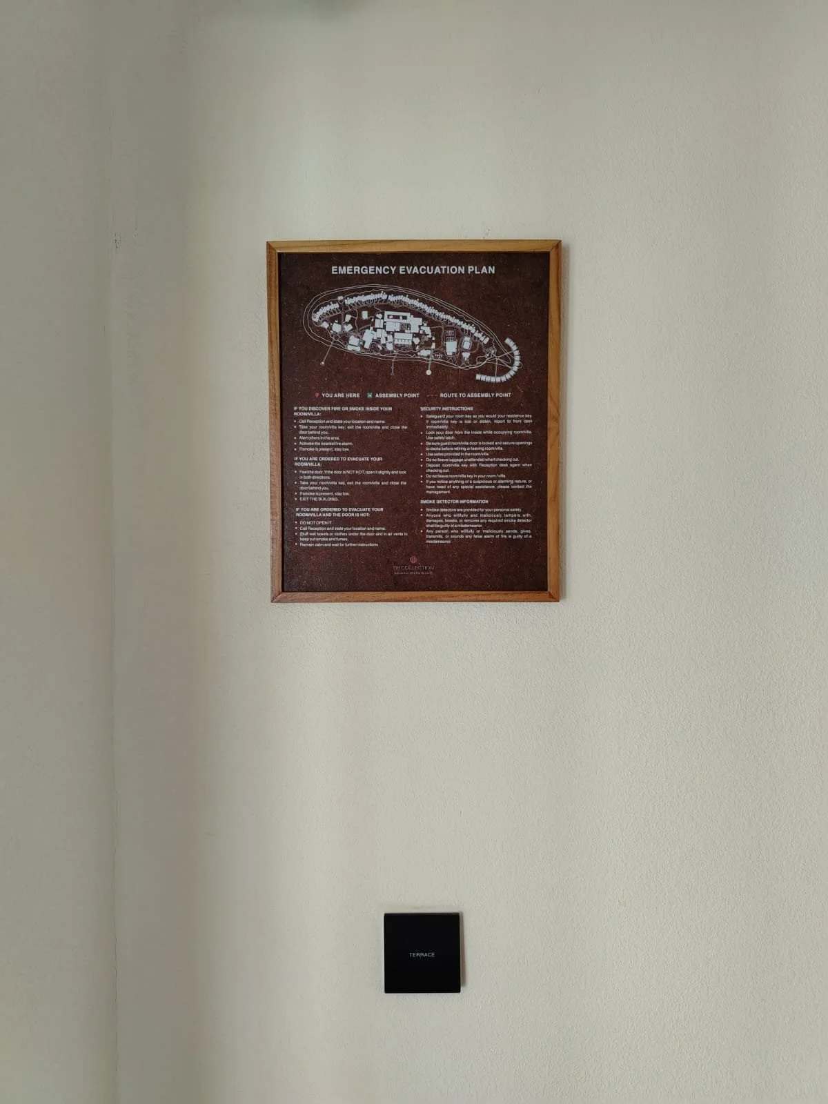 A framed emergency evacuation plan on a beige wall, with a black Terrace panel below it.