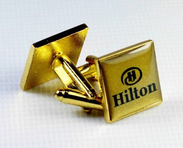 Gold Hilton hotel cufflinks with the Hilton logo.