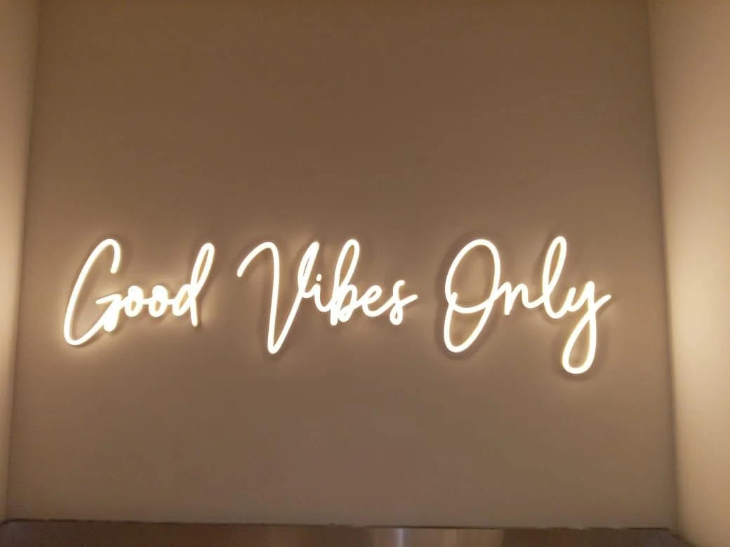 Neon sign on wall that reads 'Good Vibes Only' in white cursive font.
