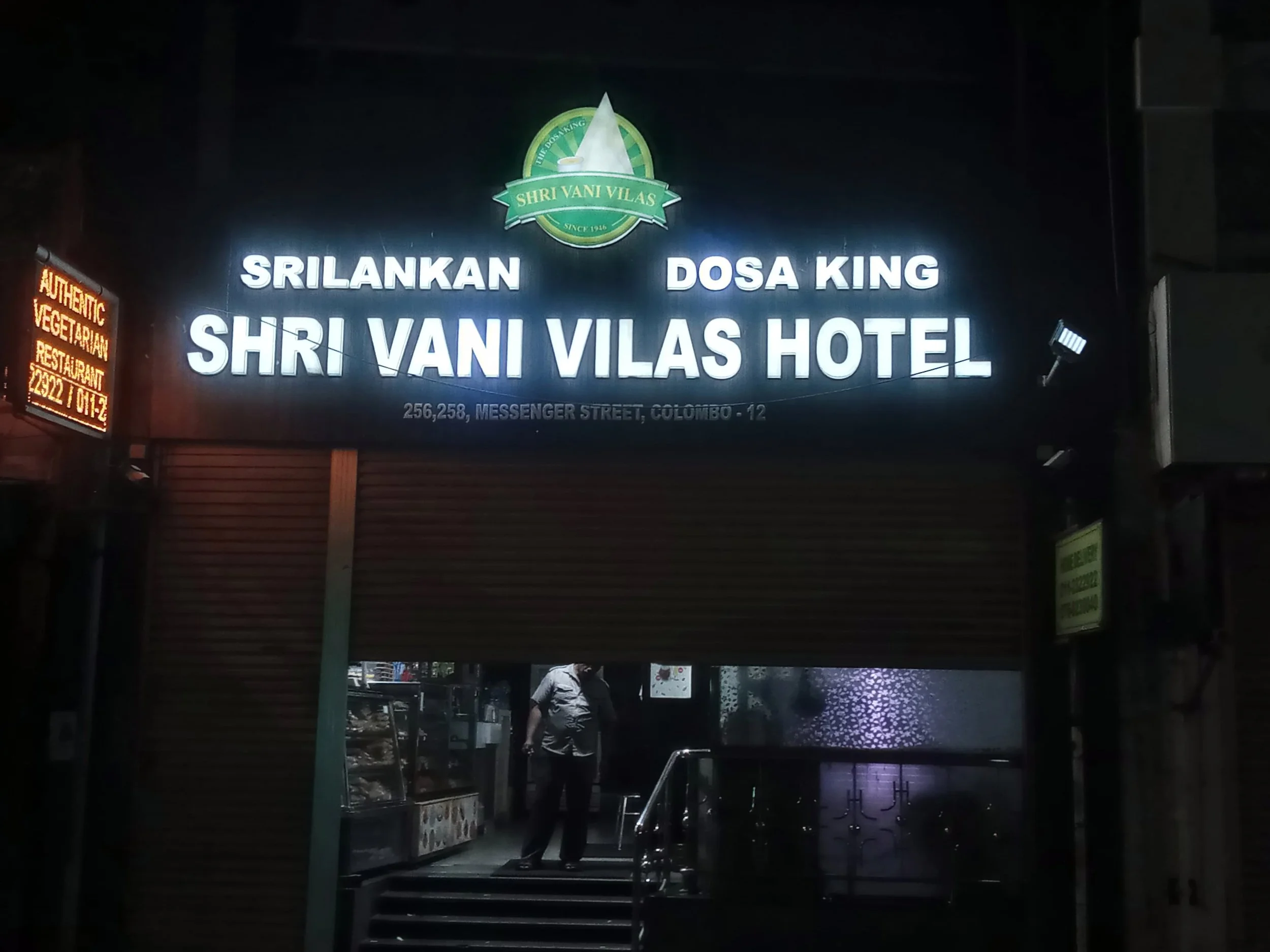 Sign for Shri Vani Vilas Hotel with the words 'Sri Lankan Dosa King' above it, located on Messenger Street in Colombo, Sri Lanka, taken at night.
