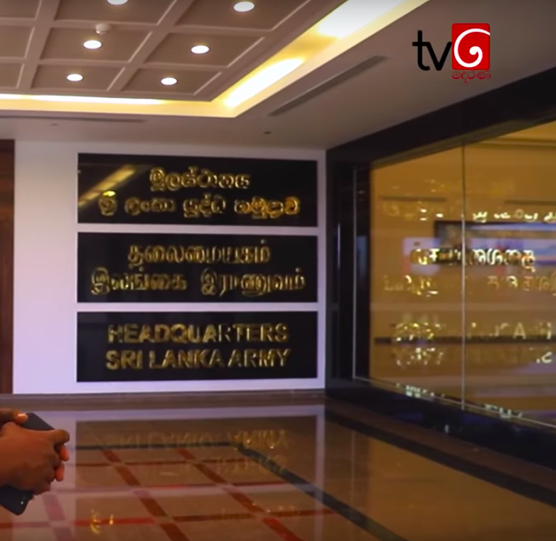 Sign in a lobby with text in Sinhala, Tamil, and English that reads 'Headquarters Sri Lanka Army'.
