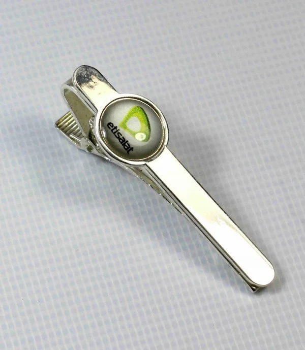 A metal nail clipper with a round logo on the handle showing the words "etzsahre" and a green symbol.