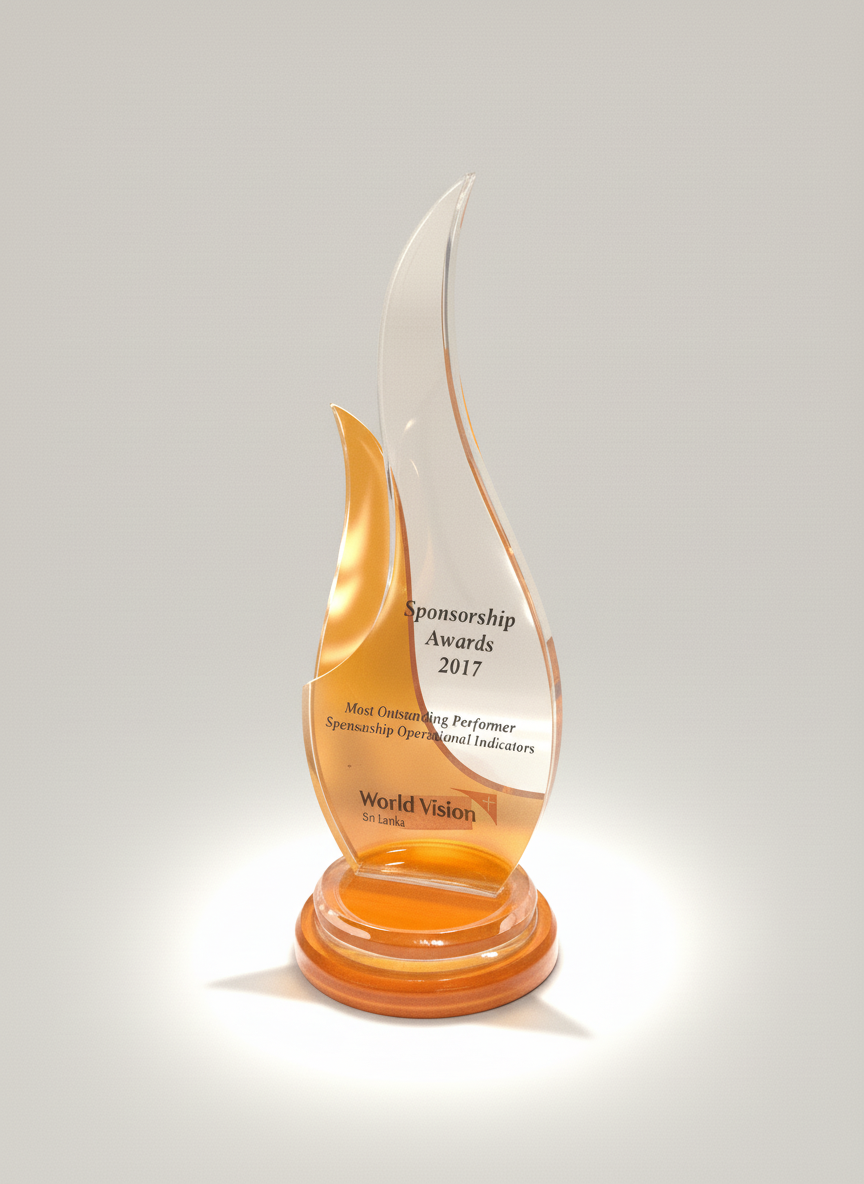 Glass award trophy with orange and clear design, inscribed with 'Sponsorship Awards 2017', 'Most Outstanding Performer', and 'World Vision Sri Lanka' on a white background.