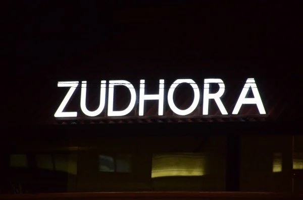 Backlit sign displaying the word 'ZUDHORA' in capital letters.