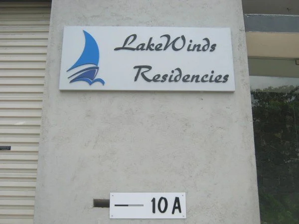 Sign for LakeWinds Residences with a blue sailboat logo, and a smaller sign below with '10A' on it.